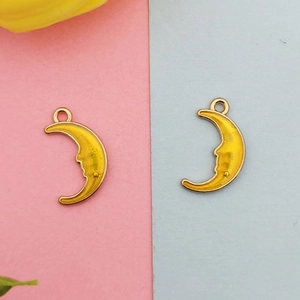 Macro shot of yellow enamel moon face alloy charms with glitter for DIY jewelry making