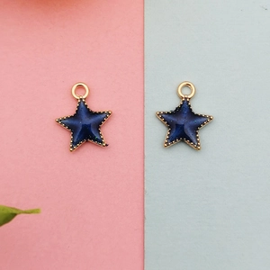 Detailed view of dark blue enamel star charms with gold beaded edges and hanging loops