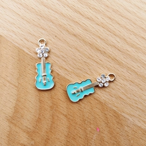 Detailansicht goldener Gitarren-Anhänger mit cyanblauer Emaille und kleinen Diamanten