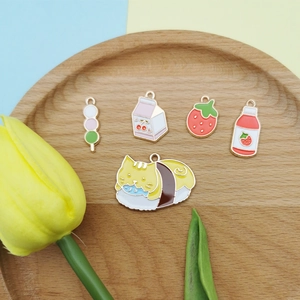 Pendentifs en émail de style japonais avec fraise et chat sushi sur un plateau en bois