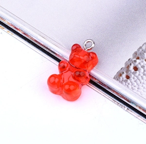 Close-up of translucent red resin gummy bear charm with silver metal eyelet hook for DIY