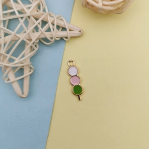 Détail d'un pendentif dango tricolore émaillé avec bordure dorée pour bijoux artisanaux