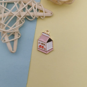 Détail d'un pendentif brique de lait rose avec motif cerise et anneau doré pour DIY