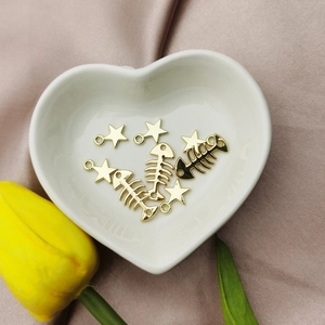 Pendentifs DIY en alliage d'or en forme d'étoile et d'arête sur une coupelle en cœur