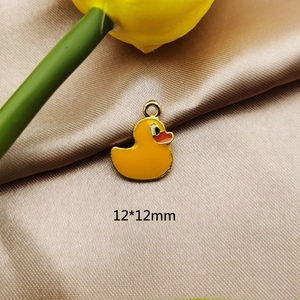 Makroansicht eines 12x12mm gelben Emaille-Entenanhängers mit goldenen Metallkanten