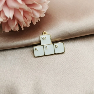 Detail of white and gold WASD keyboard key charms on elegant rose gold satin