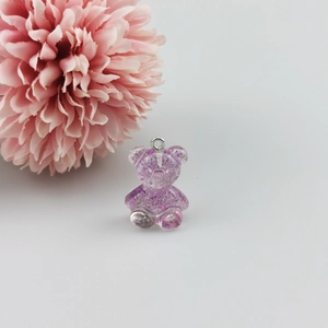 Detailopname van paarse glitterhars beer hanger met zilveren metalen ring voor DIY sieraden
