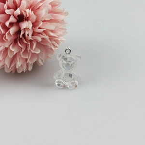 Detail van een harsbeerbedeltje met glitter en metalen ring voor DIY-sieradenaccessoires