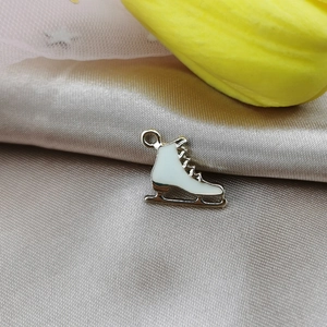 Detalle de colgante de patín de hielo en esmalte blanco sobre seda para crear joyas