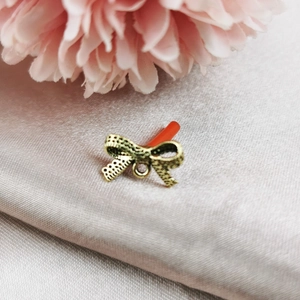 Vue macro de breloques nœud dorées avec texture évidée pour la création de bijoux