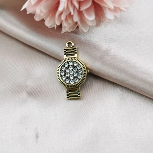 Détail macro du pendentif montre vintage en alliage avec strass sur fond de soie