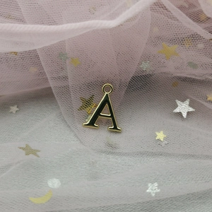 Détail d'un pendentif lettre A en or et émail noir avec anneau pour création de bijoux DIY
