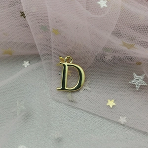 Gros plan détaillé d'un pendentif lettre D doré pour la création de bijoux DIY