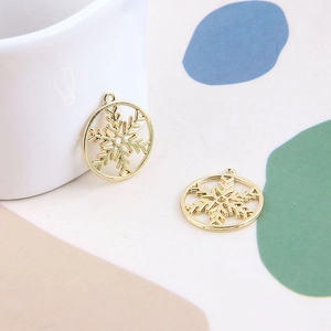 Gros plan de breloques flocons dorés pour bijoux DIY avec design ajouré et poli brillant