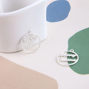 Vue détaillée de breloques Merry Christmas en argent pour création de bijoux DIY