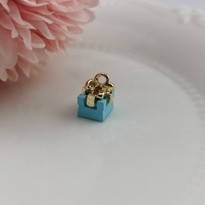 Detailansicht hellblauer Geschenkbox-Anhänger mit goldener Schleife für DIY-Schmuck