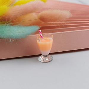 Macro shot of miniature bubble tea resin charm in cocktail glass with striped straw