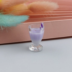 Macro shot of miniature purple milkshake charm with striped straw for DIY crafts