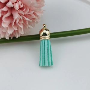 Detailed view of mint green suede tassel with gold metal cap for DIY jewelry