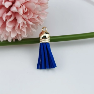 Close-up of a dark blue faux suede tassel pendant with a golden metal cap and ring