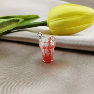 Detailed macro of a miniature resin sundae pendant with red and white swirls for DIY
