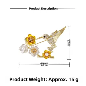 Vue détaillée de la broche colibri avec fleurs en émail et strass étincelants
