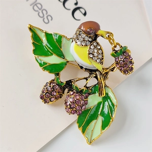 Vintage gold bird brooch with enamel strawberry and sparkling crystals on card