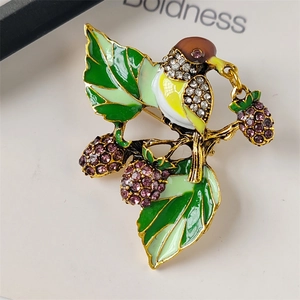 Vintage hummingbird brooch with purple crystal berries and green enamel leaves