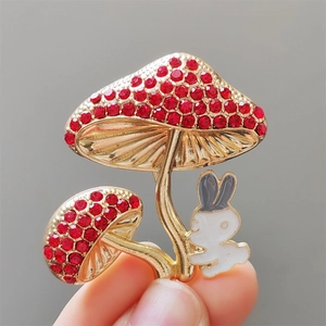 Vue détaillée de la broche avec champignons en strass et lapin en émail blanc