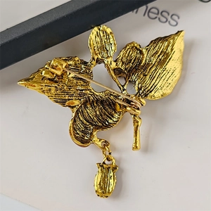 Macro detail of gold-plated strawberry brooch back with pin clasp and textured finish