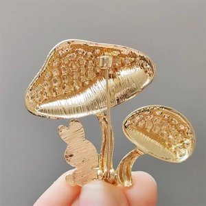 Vue macro de l'arrière d'une broche champignon dorée avec fermoir épingle de sûreté