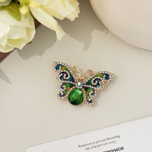 Bunte Schmetterlingsbrosche mit grünem Kristall und Emaille auf goldenem Sockel