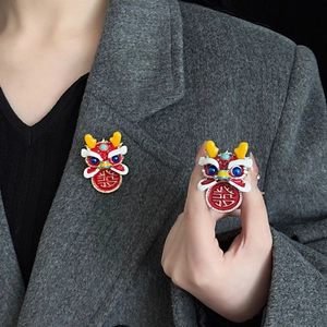 Traditional Chinese New Year lion dance brooch with festive red glaze and double happiness charm