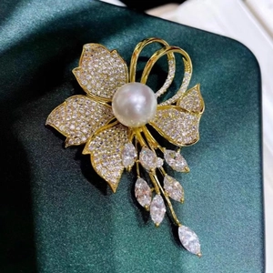 Élégante broche fleur dorée avec perle blanche et cristaux de zircone marquise