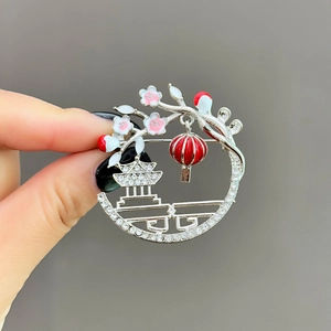 Detailed macro view of an vintage lantern brooch with enamel plum blossoms and crystals