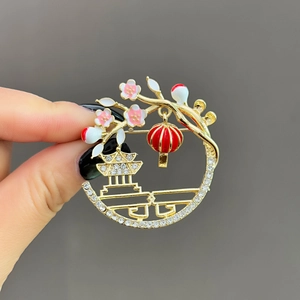 Macro shot of circular Chinese style lantern brooch with pavé crystals and gold detail