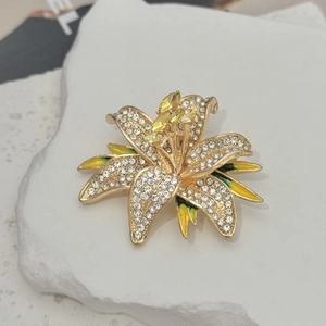 Detail of crystal lily brooch with yellow marquise gemstones and enamel finish