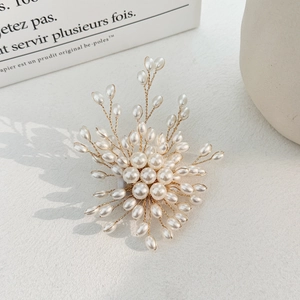 Macro detail of fireworks pearl brooch with gold wire weaving and cream white pearls