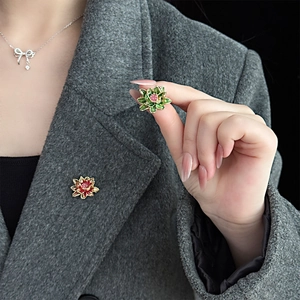Exquisite enamel lotus brooches in green and red pinned on a grey wool coat