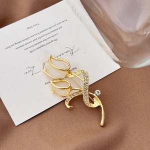 Broche tulipe dorée élégante avec pétales d'opale et strass brillants sur surface textile