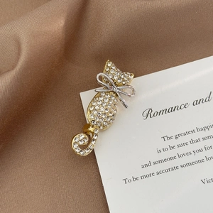 Exquisite gold-plated cat brooch with crystal rhinestones on elegant silk background