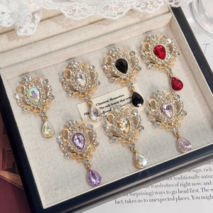 Set of 7 vintage gold crystal brooches with teardrop rhinestones on lace background