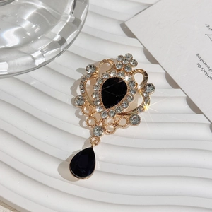 Detail of vintage gold crystal brooch with black teardrop gemstone and sparkling rhinestones