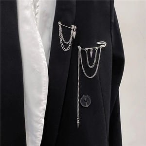 Silver fringe brooch with metal chains and geometric pendants on black suit lapel