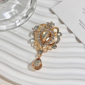 Close-up of vintage gold brooch with amber pear-shaped crystals and shimmering rhinestones