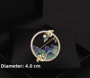 Détail d'une broche chinoise de 4,0cm avec montagnes en émail et cadre doré élégant