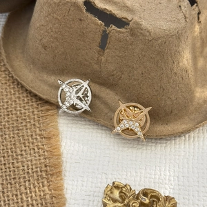 Vue détaillée des broches hexagrammes or et argent avec des strass en cristal brillants