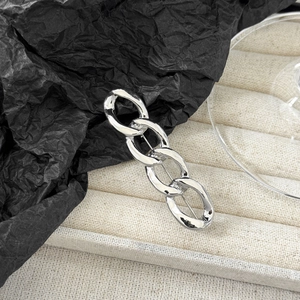 Close-up of polished silver chain brooch with four interconnected oval metal rings