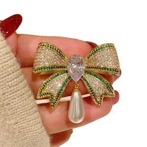 Elegant vintage gold bow brooch with white zircons, green crystals and pearl pendant