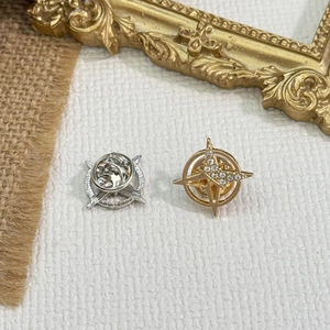 Détail de broches en forme d'étoile avec strass et fermoirs papillon en métal poli